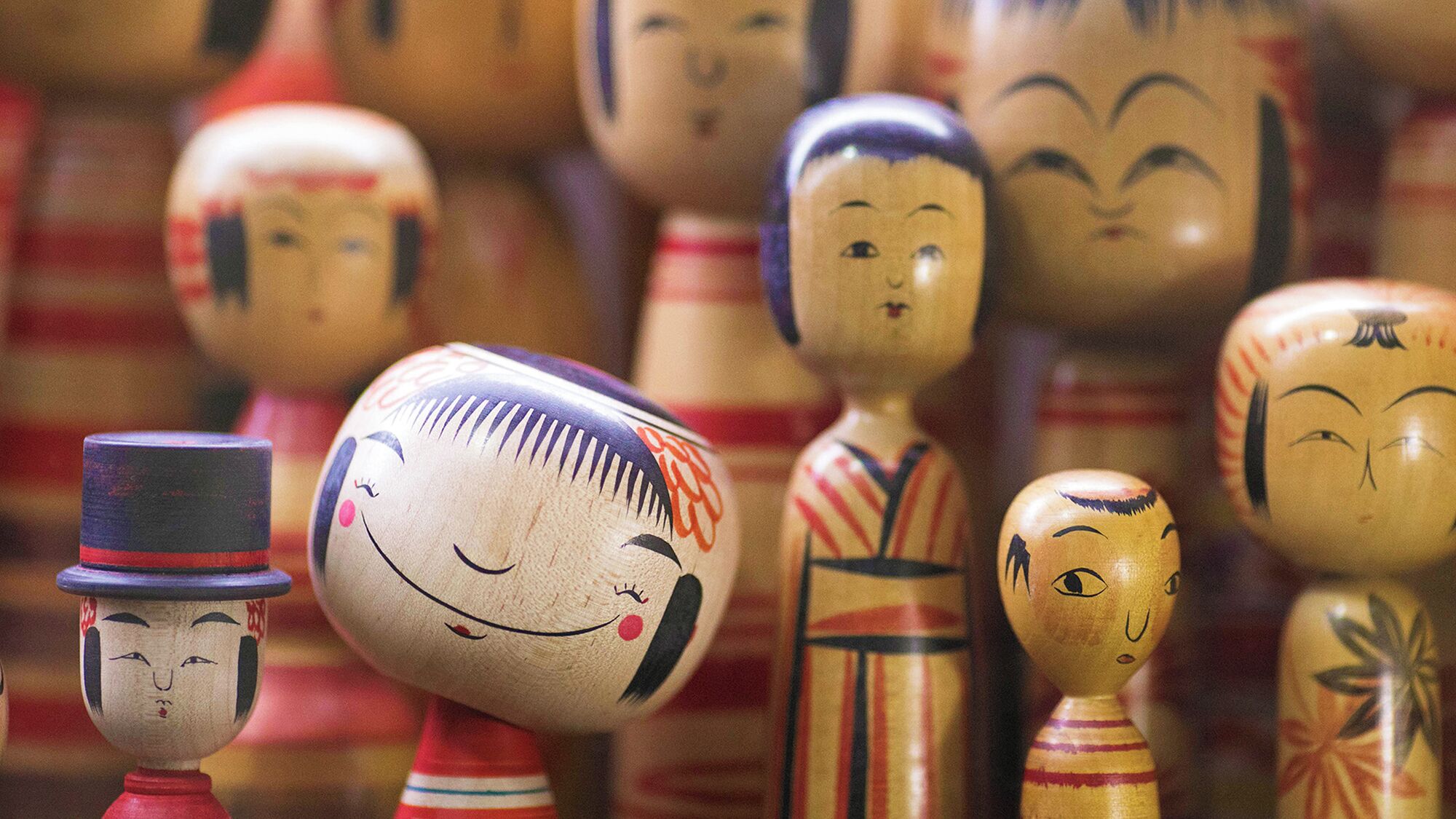 Un grupo de figuras de madera con rostros y vestimenta pintados, dispuestas muy juntas.