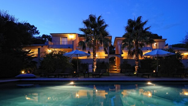 A luxurious resort with a swimming pool, palm trees, and outdoor seating areas. - Charming *** villa with heated pool, near downtown (porto vecchio)
