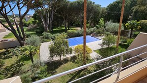A balcony with a view of a garden, including a pool and palm trees. - Charming *** villa with heated pool, near downtown (porto vecchio)