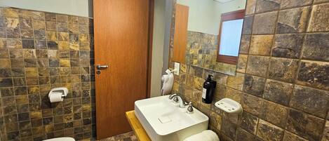 A bathroom with a white sink, a mirror, a towel, and a toilet.