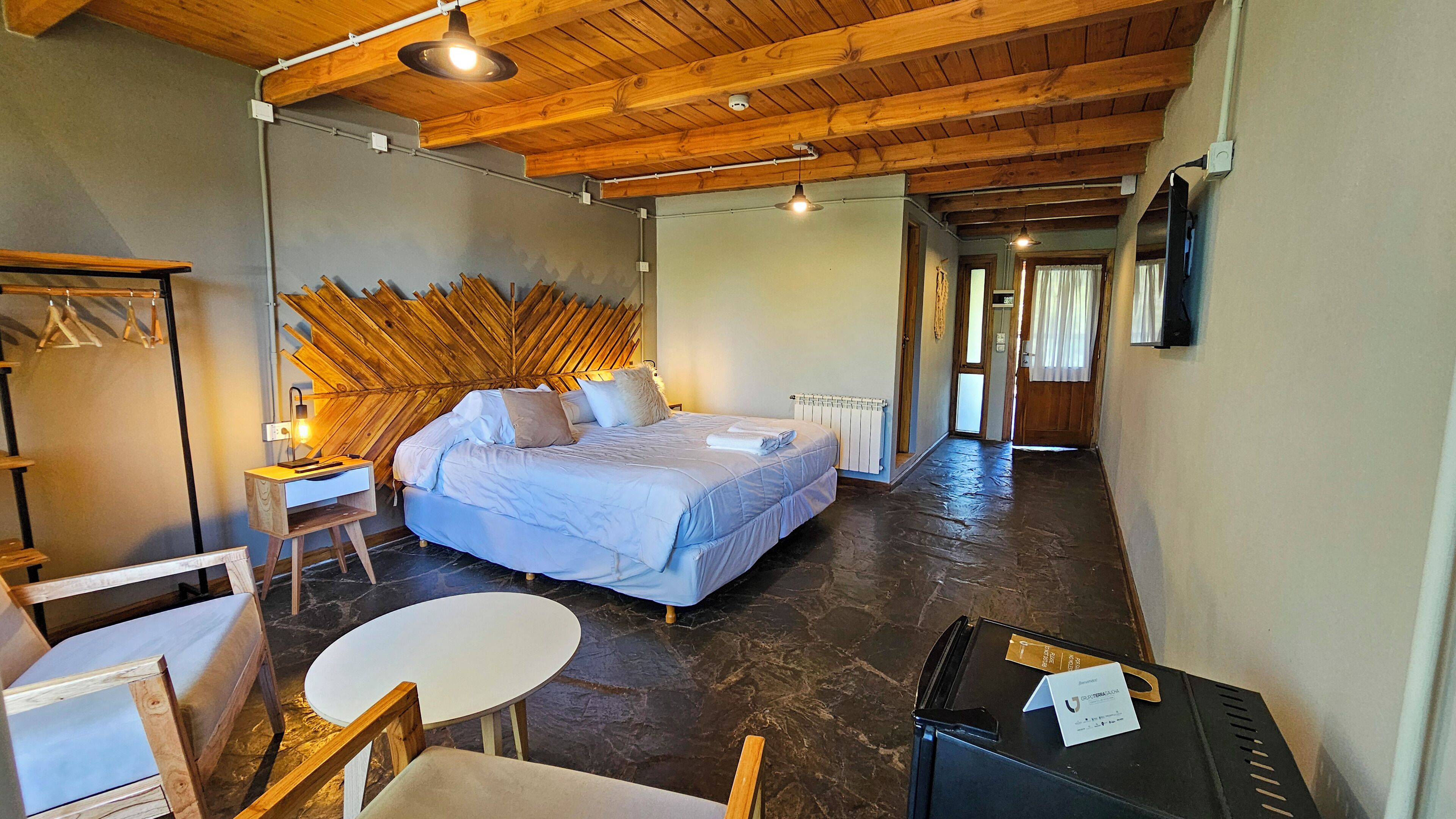 Un dormitorio con cama, escritorio, silla y mesa.