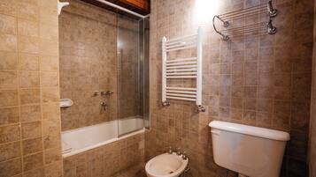 A bathroom with a bathtub, a shower, a bidet, and a toilet.