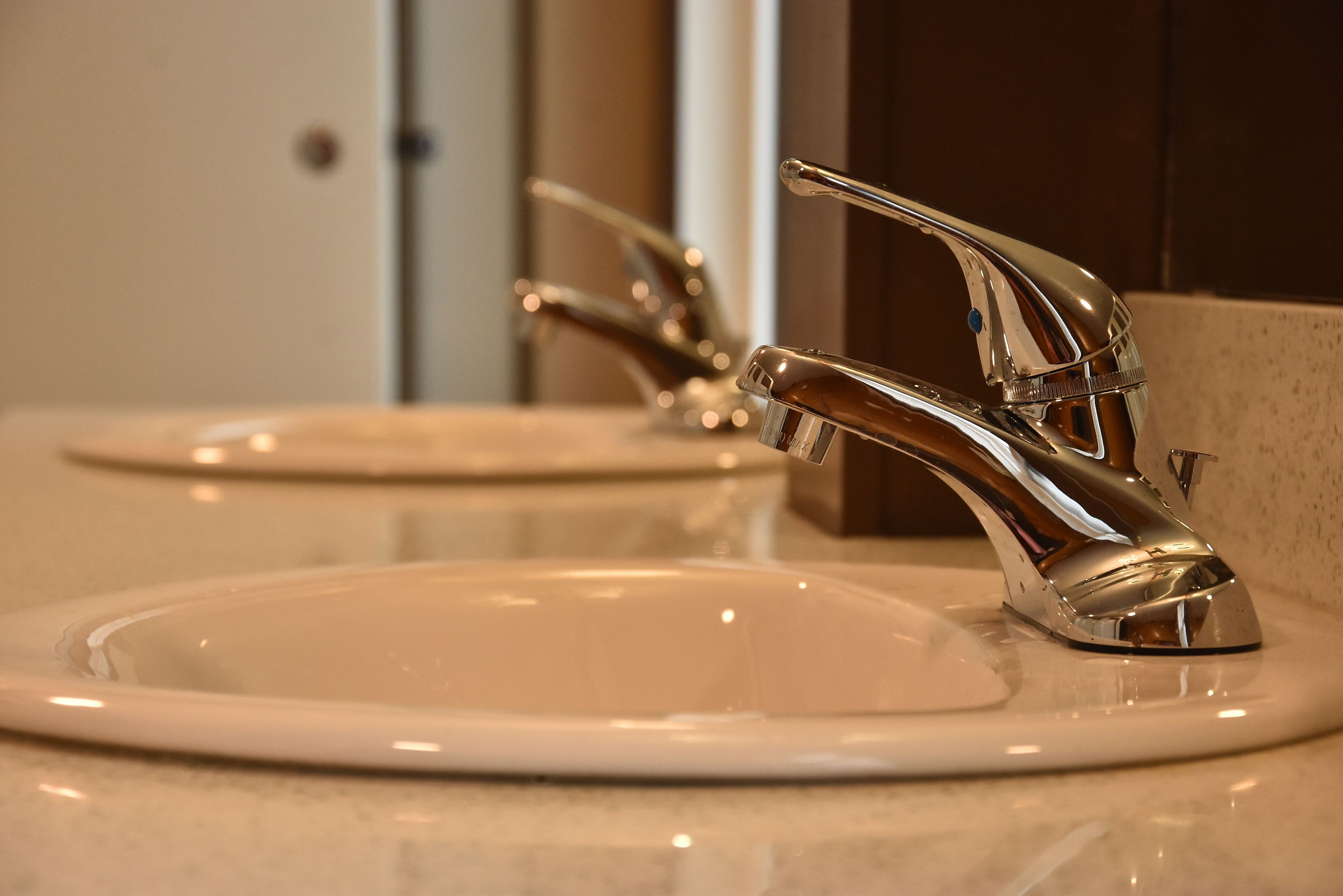 A bathroom sink with a chrome faucet and a mirror above it.