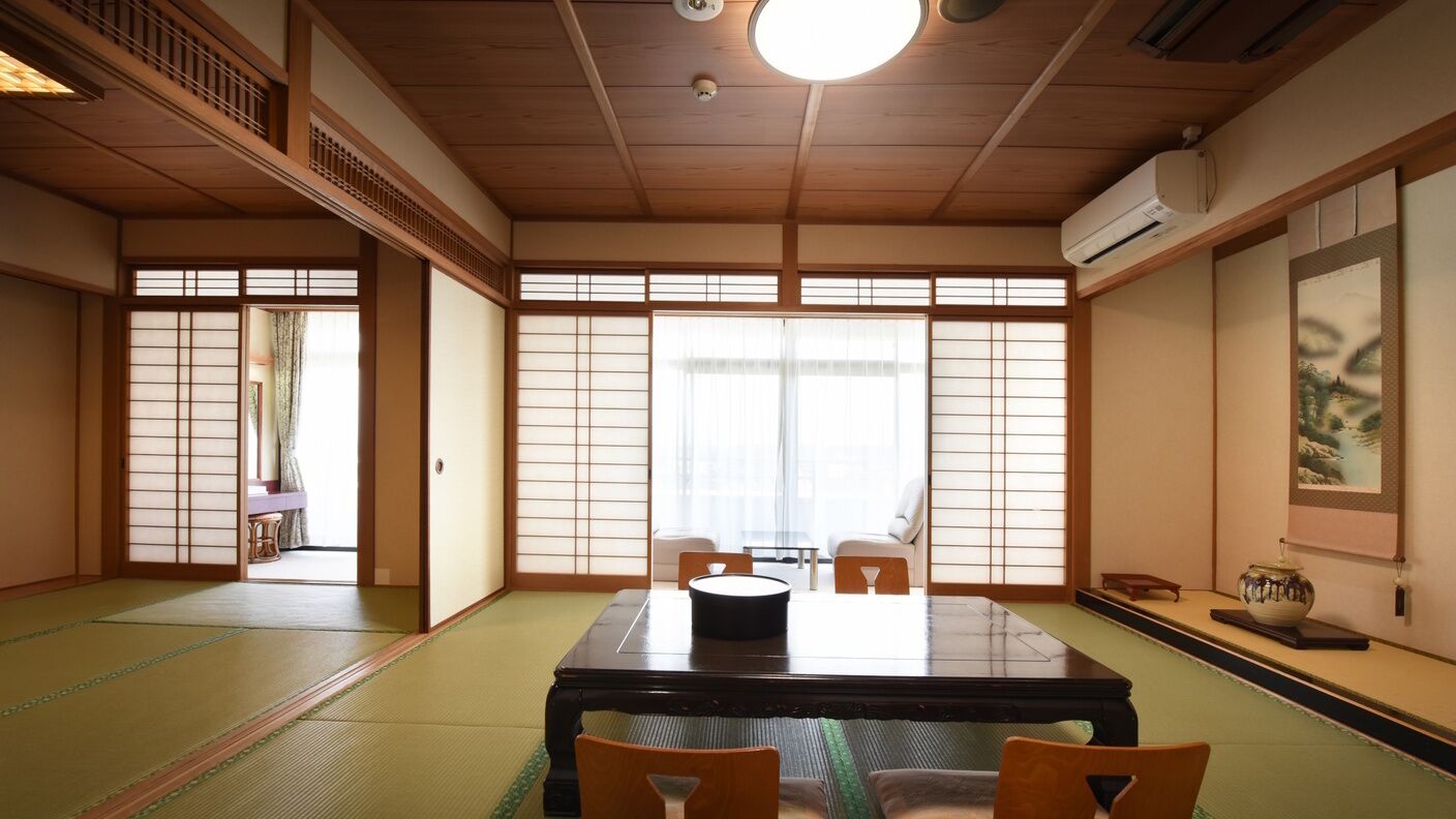 Een traditionele Japanse kamer met tatami vloerbedekking, een lage tafel en schuifdeuren.