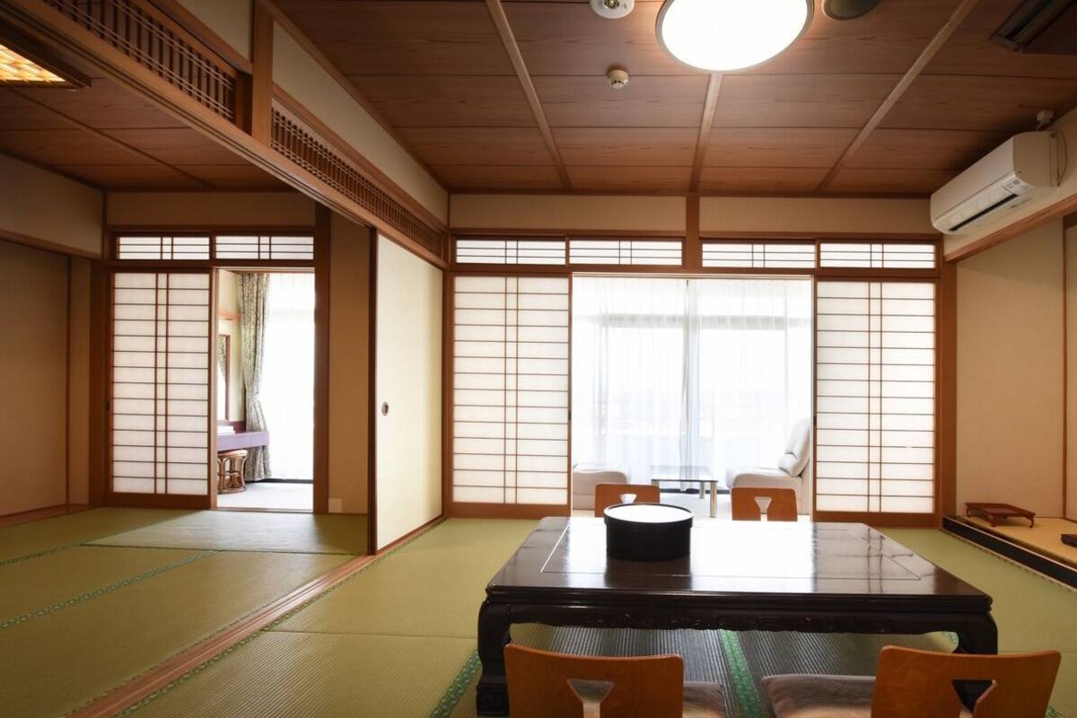 Perinteinen japanilainen huone, jossa on tatamimatto, matala pöytä ja liukuvat ovet.