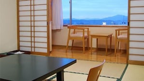Une pièce avec vue sur les montagnes, une table, des chaises et une porte coulissante.