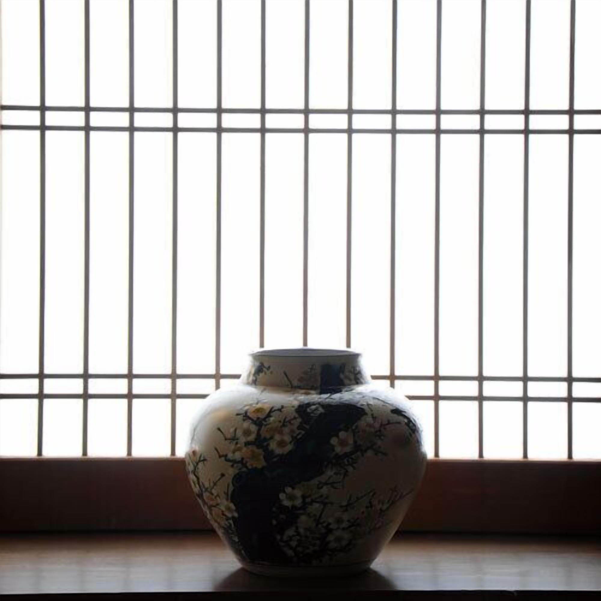 A vase with floral patterns on a table.