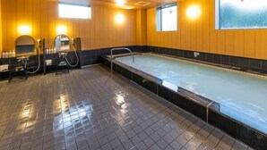 Piscina com piso de azulejo, paredes de madeira e um banco.