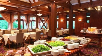 A buffet setup with multiple tables, chairs, and a variety of food items.