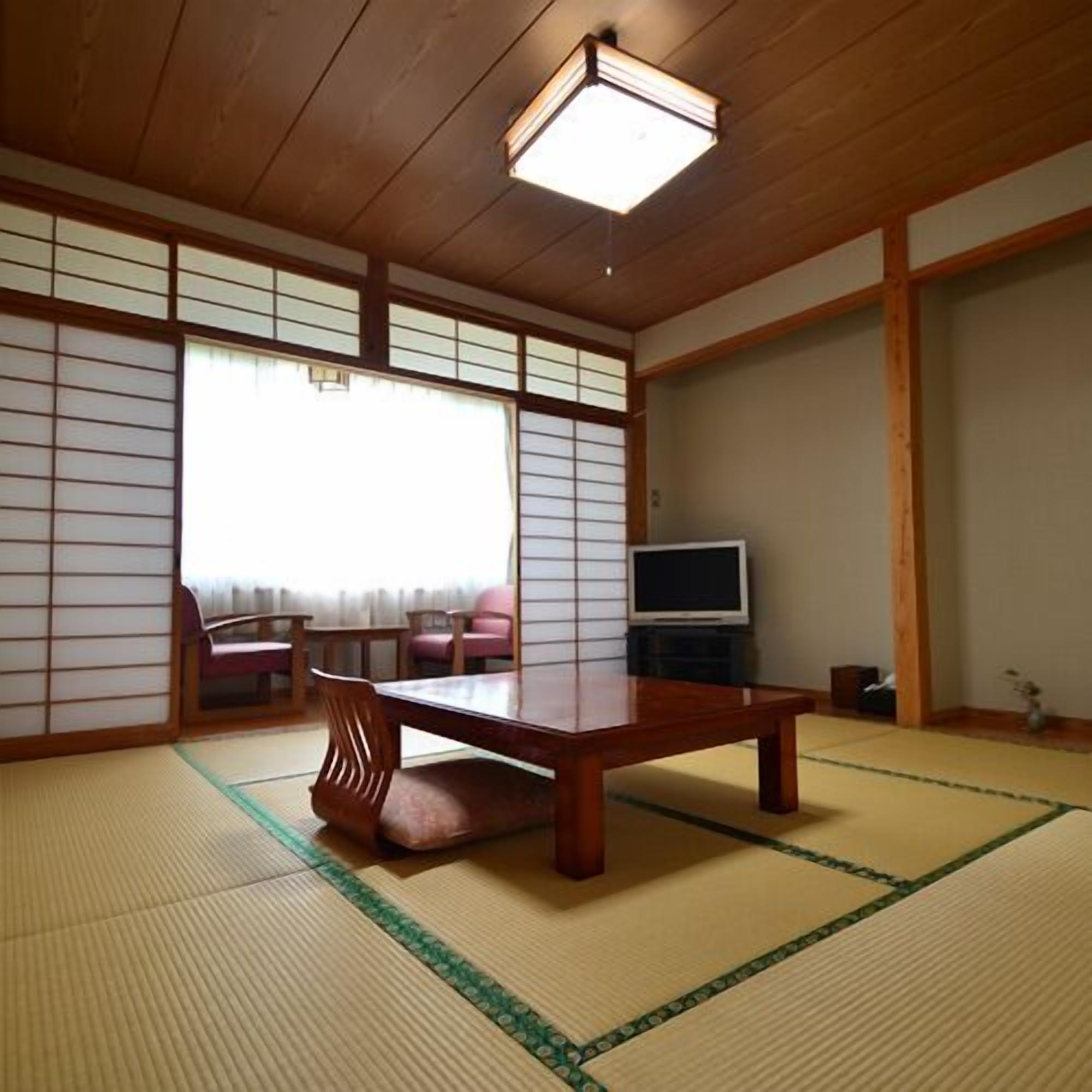 Una habitació japonesa tradicional amb tatami, una taula de fusta baixa i panells corredissos shoji.