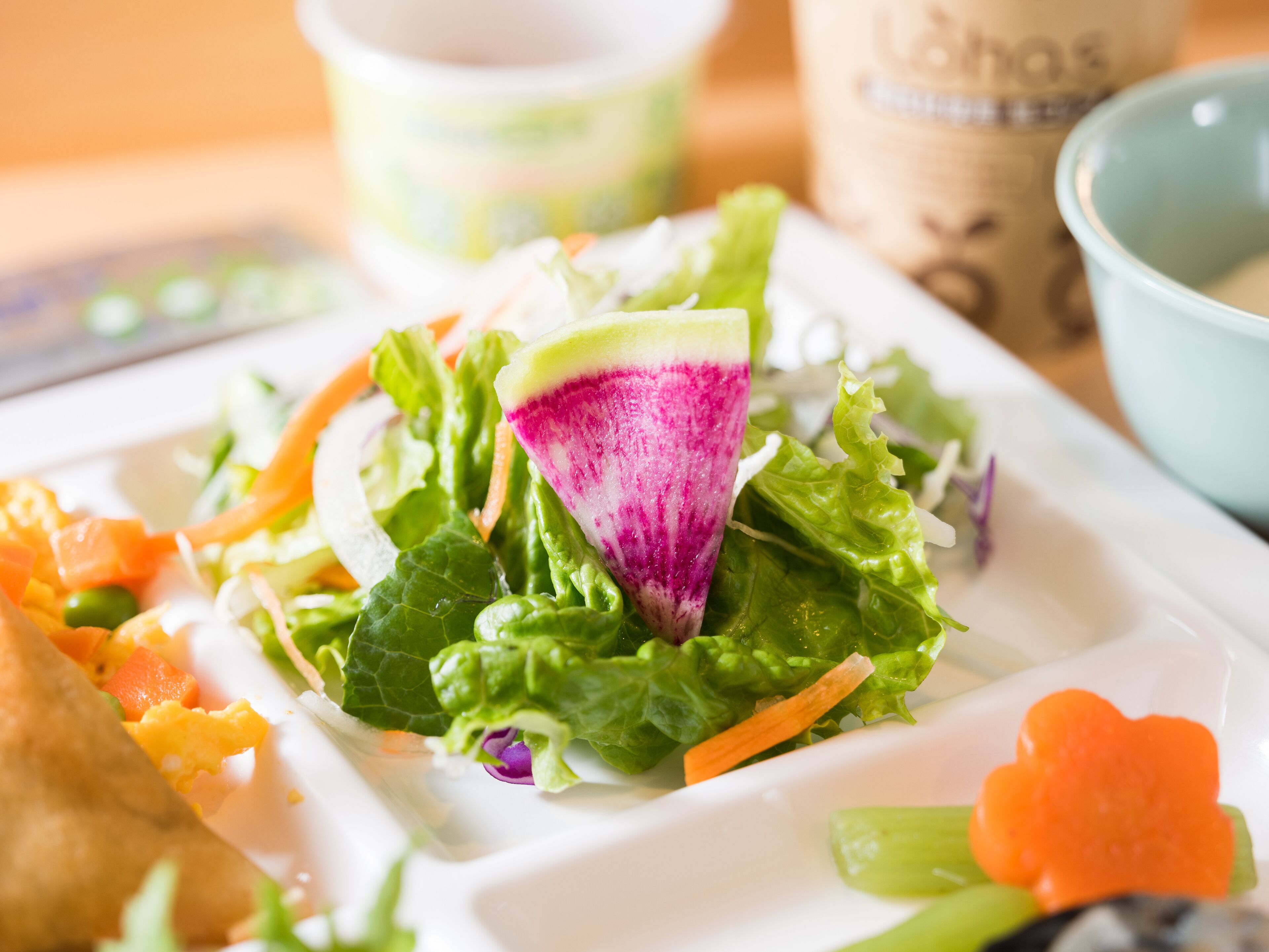 Ein Salat mit verschiedenen Gemüsesorten und einer roten Bete auf einem weißen Teller.