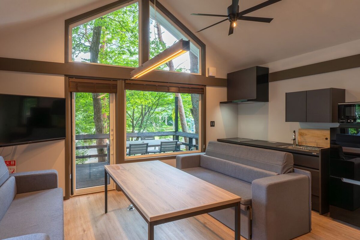 A modern interior with a large TV, a dining area, and a kitchen.
