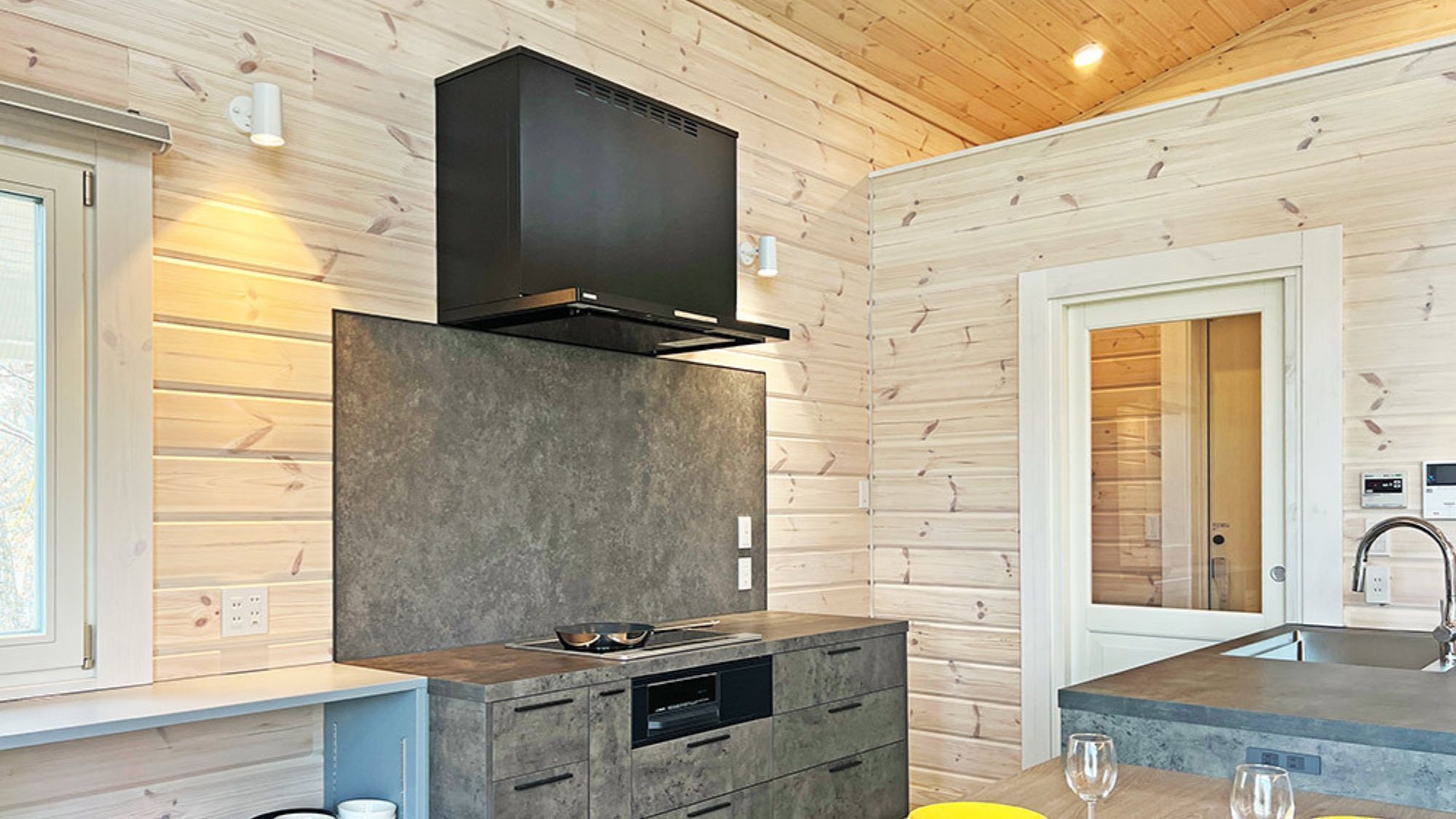 A modern kitchen with a built-in stove, a microwave, and a large window.