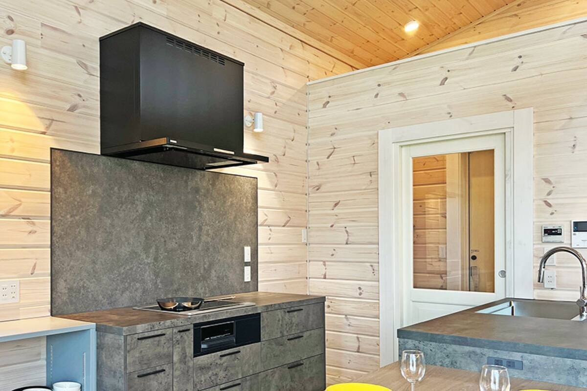 A modern kitchen with a built-in stove, a microwave, and a large window.