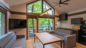 Un espacio habitable moderno con televisor grande, comedor y cocina.