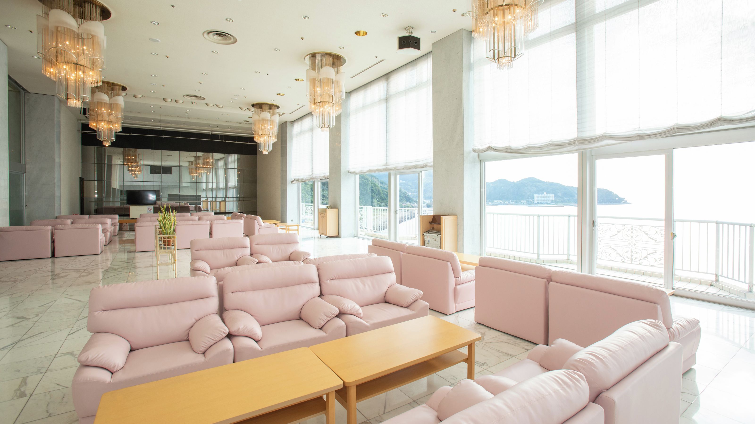 Amplia sala de estar con múltiples opciones de asientos y grandes ventanales con vistas al mar.