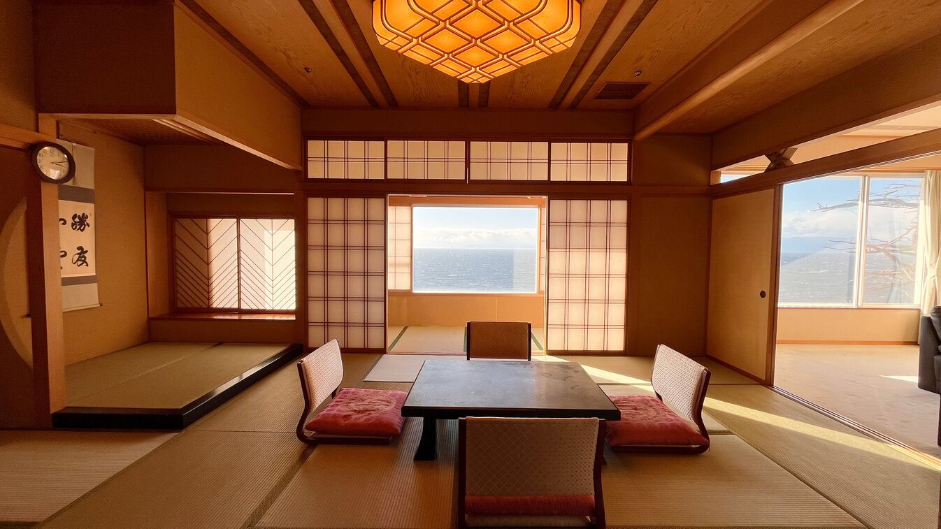 Ein traditioneller japanischer Raum mit Tatami-Böden, einem niedrigen Tisch und Schiebetüren.