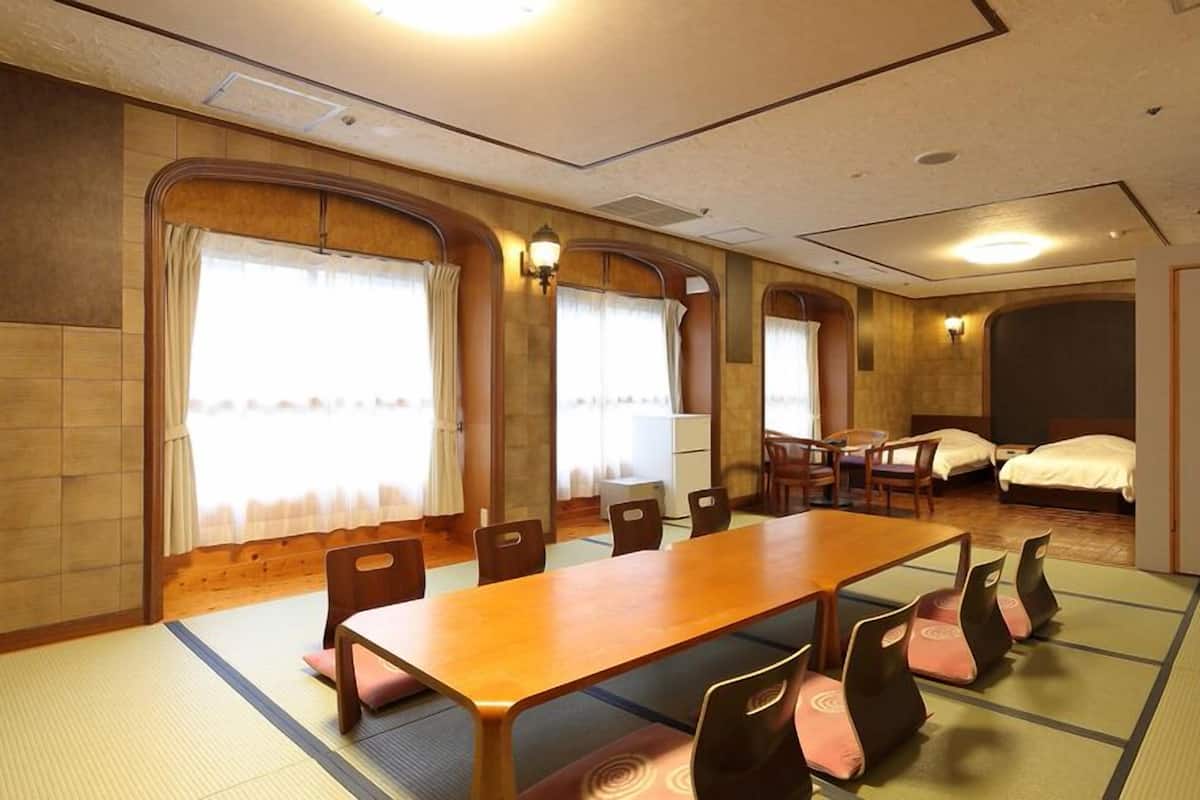 Quarto japonês tradicional com piso de tatame, uma mesa de madeira e uma cama de futon.