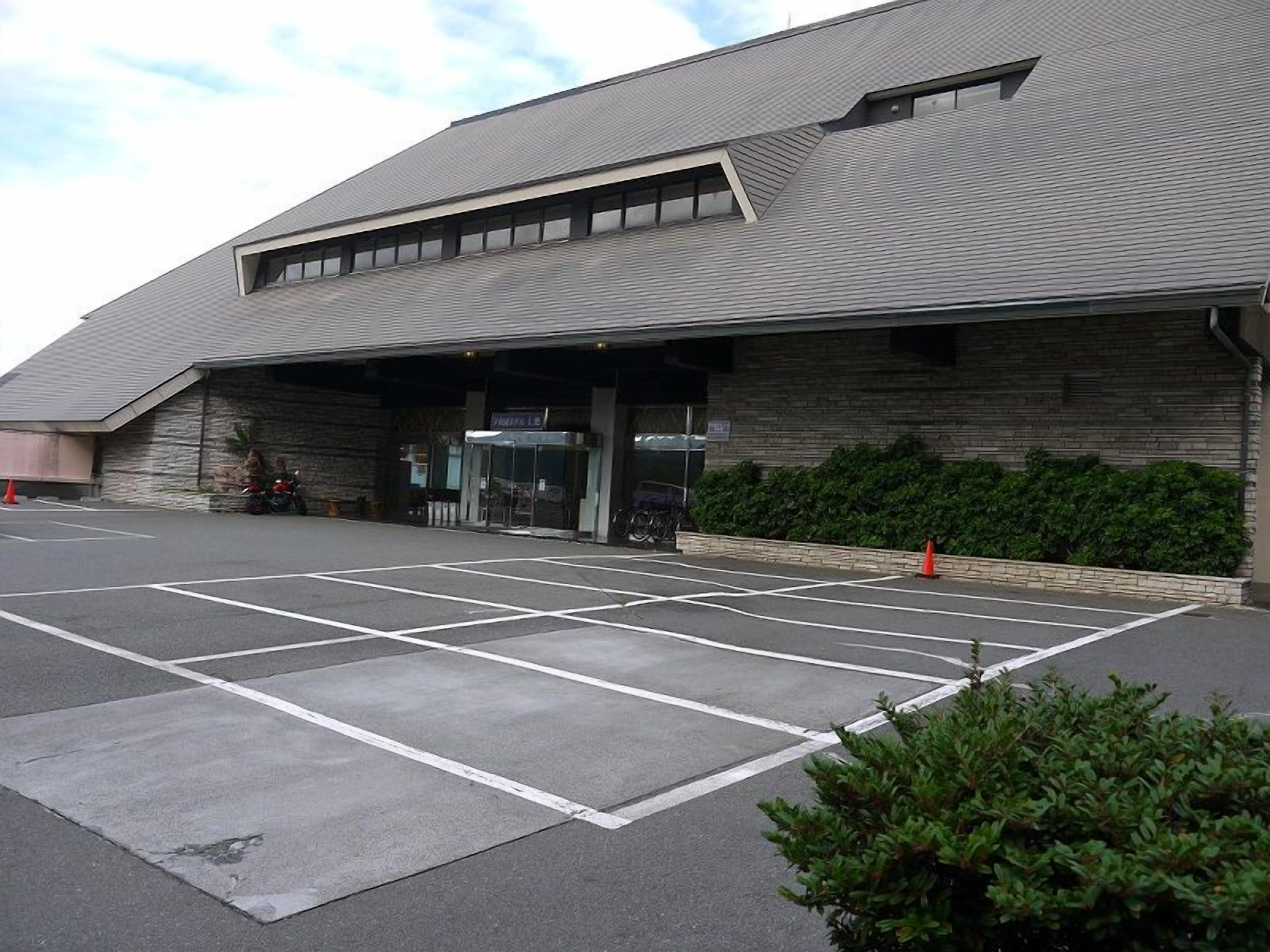 A building with a parking lot and a covered entrance.