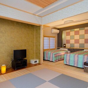 A room with two beds, a television, and an air conditioning unit. - Fukuya (Toba)