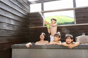 A wooden cabin with a hot tub where people are relaxing. - Hatago Ogiyama (Beppu)