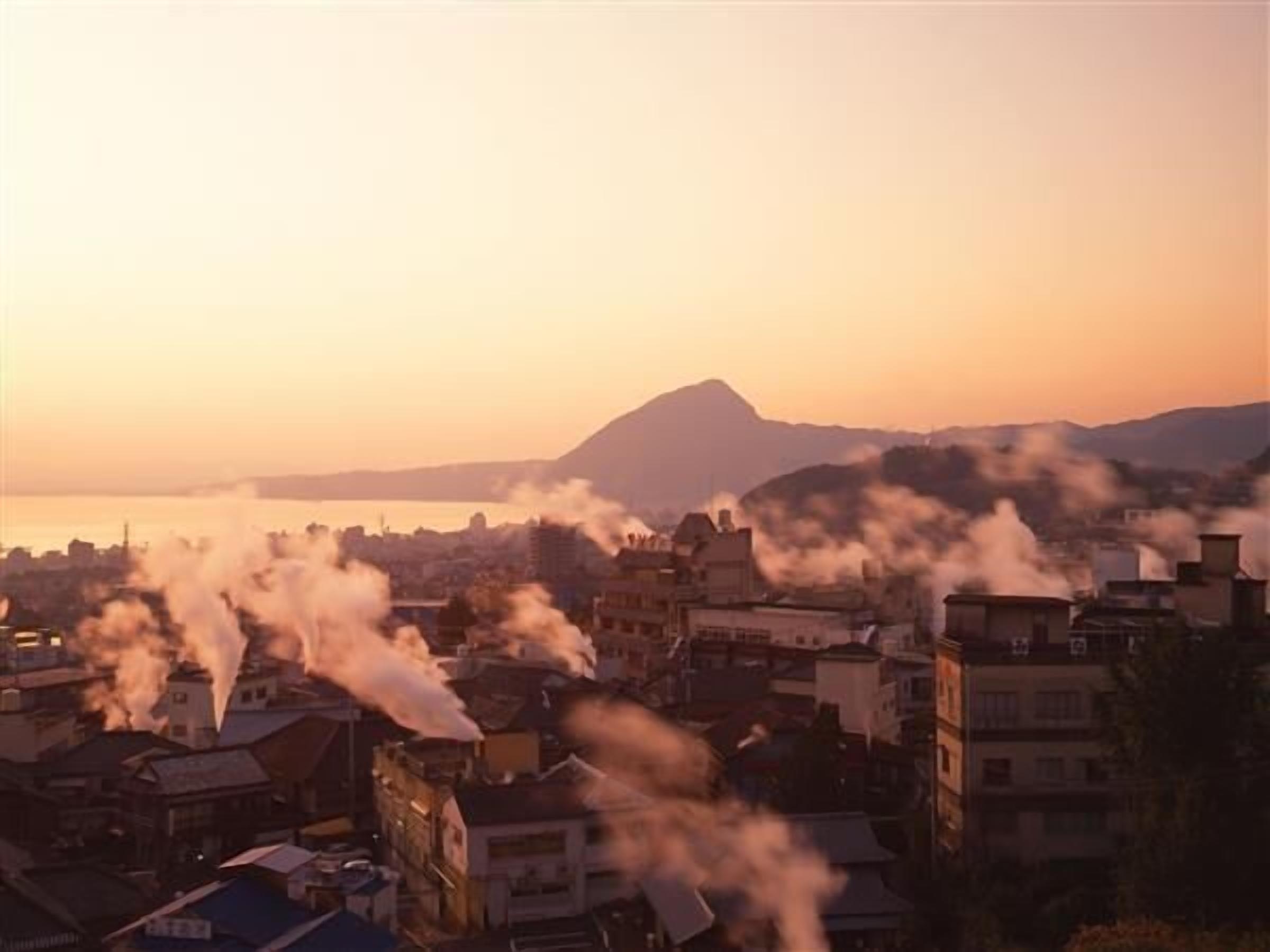 A cityscape with buildings and a mountain in the background.