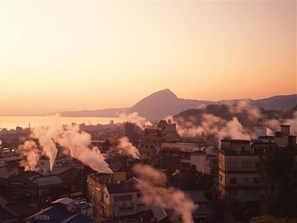 A cityscape with buildings and a mountain in the background. - Hatago Ogiyama (Beppu)