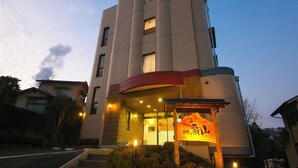 A building with a curved entrance, illuminated windows, and a sign with Chinese characters.