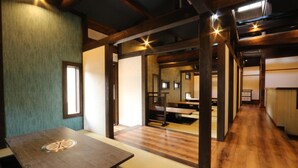 Un interior japonés tradicional con suelo de tatami, vigas de madera y puertas correderas.