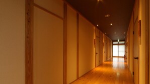 Un pasillo con suelo de madera y puertas correderas a ambos lados.