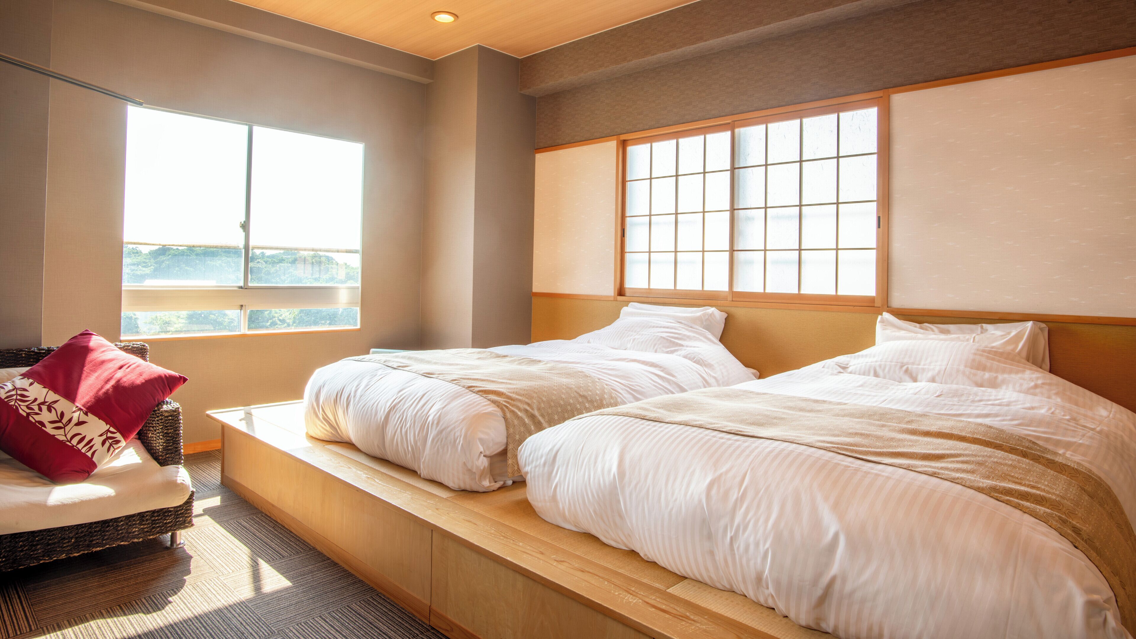 Una habitación de hotel con dos camas, una ventana con vistas y un cabecero de madera.