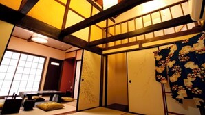 Una habitación japonesa tradicional con suelo de tatami, un divisor shoji y una cama futón.