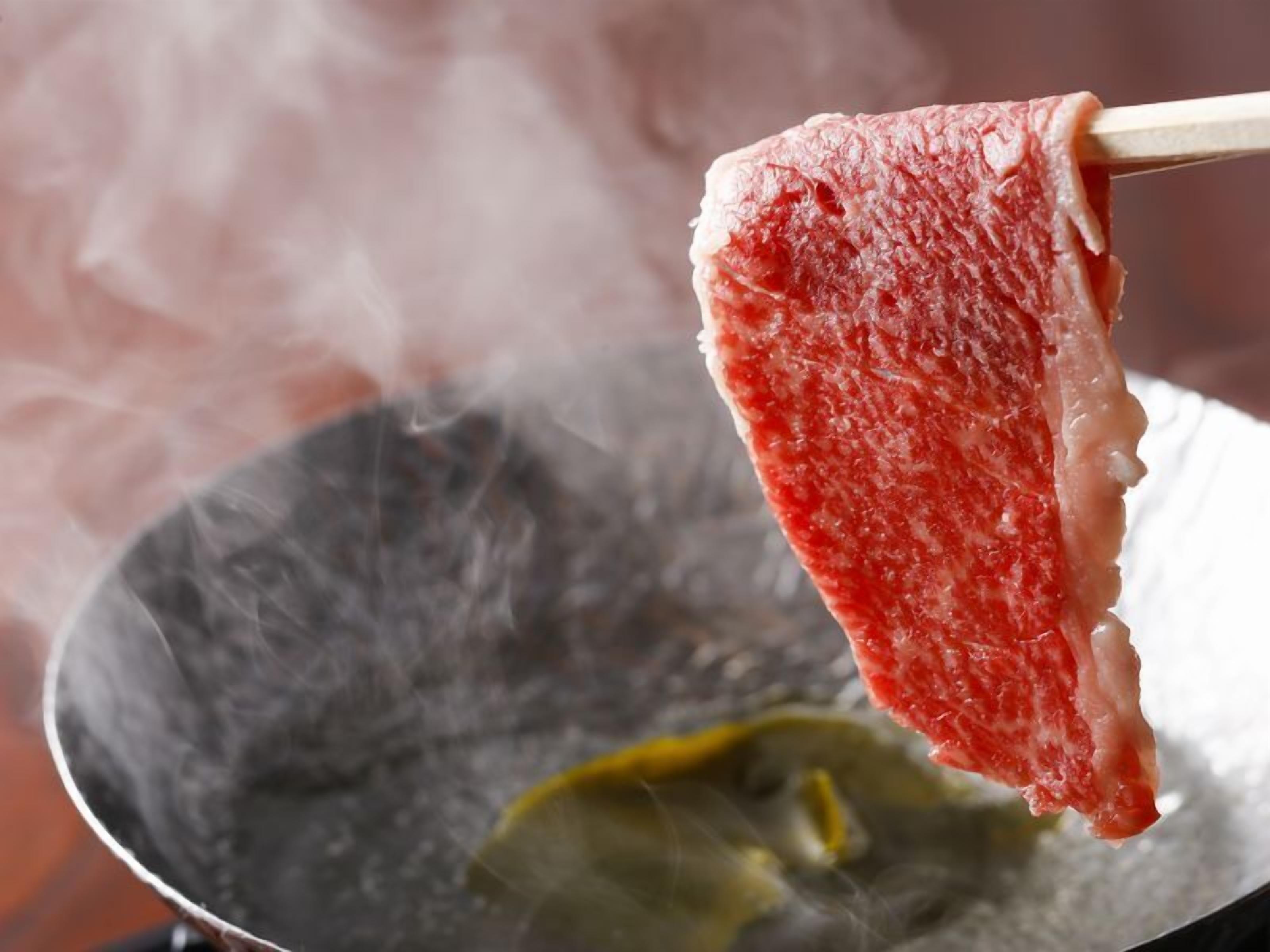 A piece of meat being cooked on a pan.