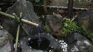 A rock garden with a bamboo structure and a small pond. - Kyomachi Onsen Kyomachi Kanko Hotel (Ebino)