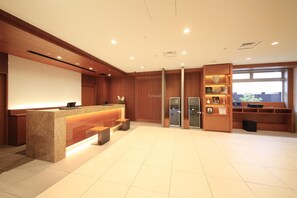 A hotel reception area with a reception desk, seating area, and a view of the city. - Richmond Hotel Nagoya Shinkansenguchi (Nagoya)