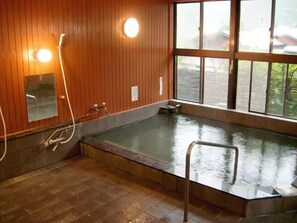 A room with a large bathtub, wooden walls, a window, and a mirror. - Minami Alps Seitaimura Healthy Misato (Hayakawa)