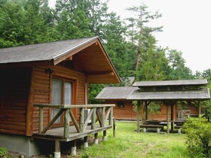 Une cabane en bois avec une véranda et une table de pique-nique.