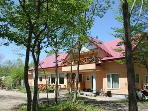 Une maison à deux étages avec un toit rouge, un balcon et une véranda.