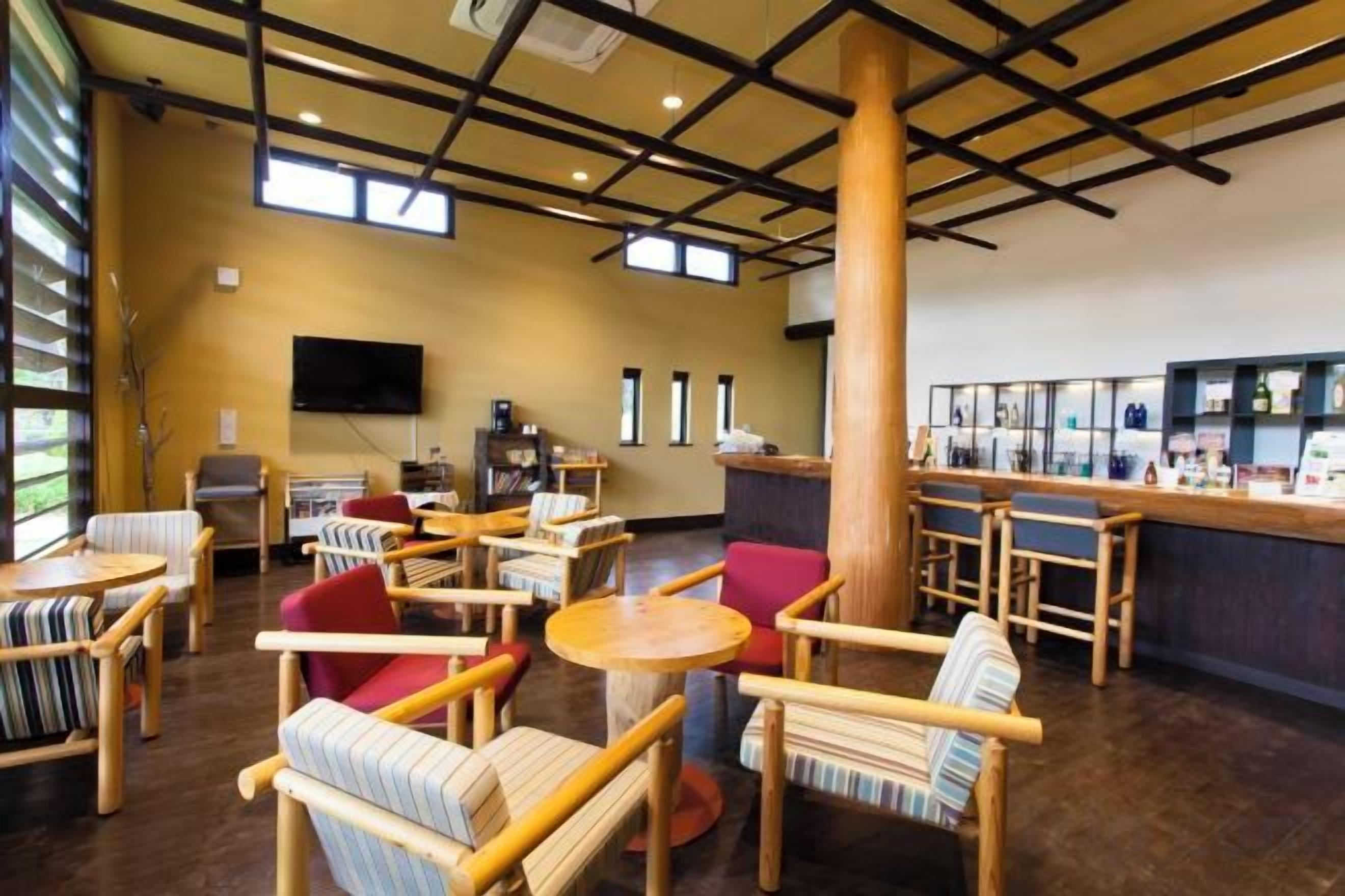 A spacious indoor area with multiple seating arrangements, a reception desk, and a television mounted on the wall.