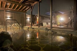 A hot spring area with a wooden deck, lounge chairs, and a stone pool. - THE FARM Resort Japan (Katori-shi)
