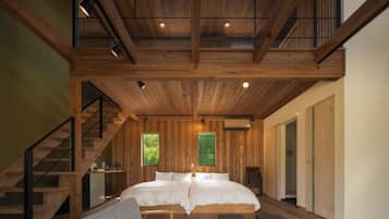 Interior de madeira com cama, escada e um pequeno espaço para sentar.