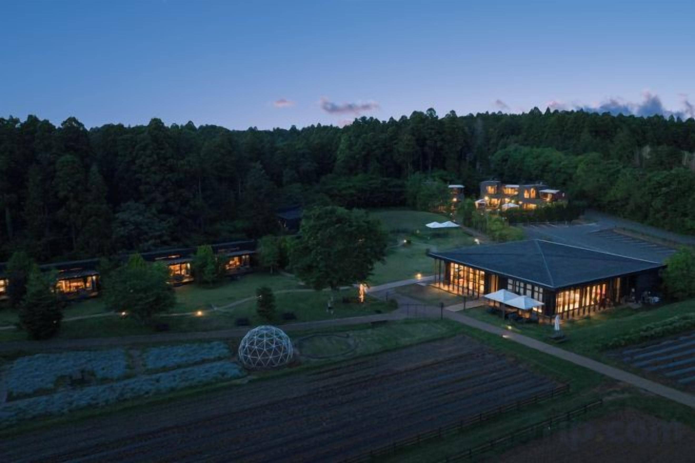 A hotel with multiple buildings, a large spherical structure, and a well-maintained garden.