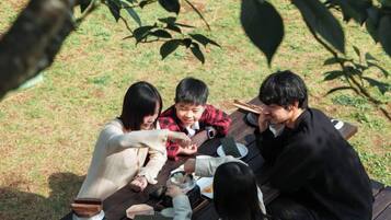 A group of people sitting around a wooden table outdoors.