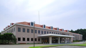 A multi-story hotel with a flat roof, large windows, and a covered entrance. - Narita no Mori Country Club (Katori)