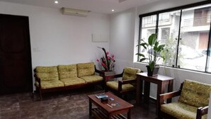 Un hall con un conjunto de sofás, una mesa de centro y una planta en maceta.