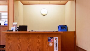 Una recepción con un reloj, una computadora portátil y un dispensador de agua azul.