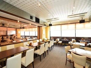 A modern restaurant with a high ceiling, large windows, and a mix of booth and table seating. - Kashihara City Hotel (Kashihara)