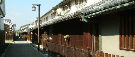 A narrow street lined with traditional wooden houses, each with a tiled roof and wooden fences.