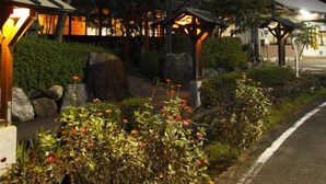 A traditional Japanese-style building with a wooden structure, surrounded by well-maintained gardens and a pathway. - Yamae Onsen Hotaru (Yamae)