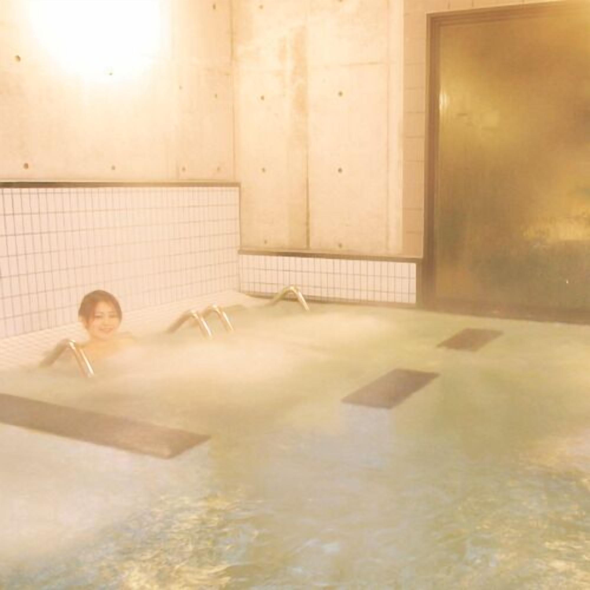A hot tub with a tiled wall and a large door.